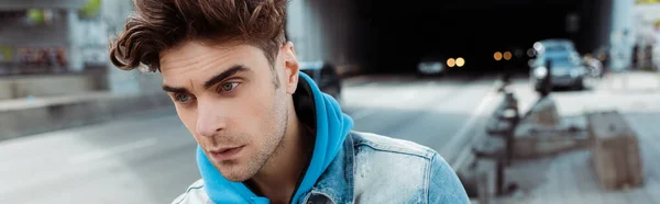 Panoramic orientation of young man looking away with road at background — Stock Photo