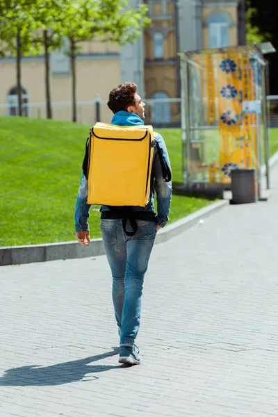 Rückansicht des Kuriers mit Thermo-Rucksack zu Fuß auf der Stadtstraße — Stockfoto