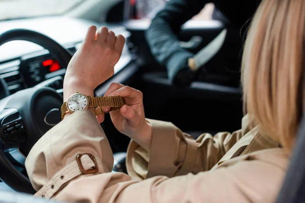 Selective focus of driver taking off wristwatch near thief with knife in car — Stock Photo