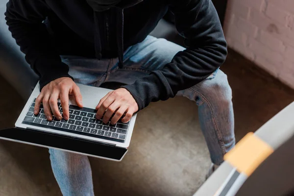 Selective focus of hacker using laptop with blank screen near atm — Stock Photo