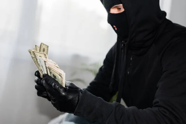 Seitenansicht des Räubers in Sturmhaube mit Dollarnoten — Stockfoto