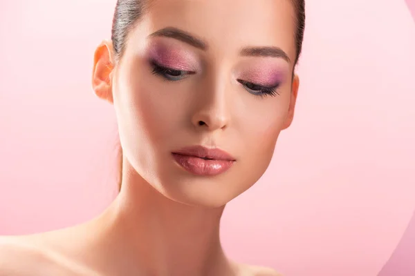 Портрет красивой обнаженной женщины с блестящим макияжем, изолированным на розовом — стоковое фото