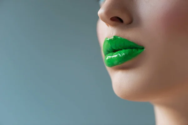 Vista recortada de la mujer con los labios verdes aislados en azul - foto de stock