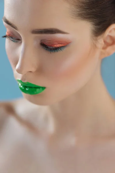 Porträt einer schönen nackten Frau mit grünen Lippen, rosa und blauem Lidschatten isoliert auf blau — Stockfoto