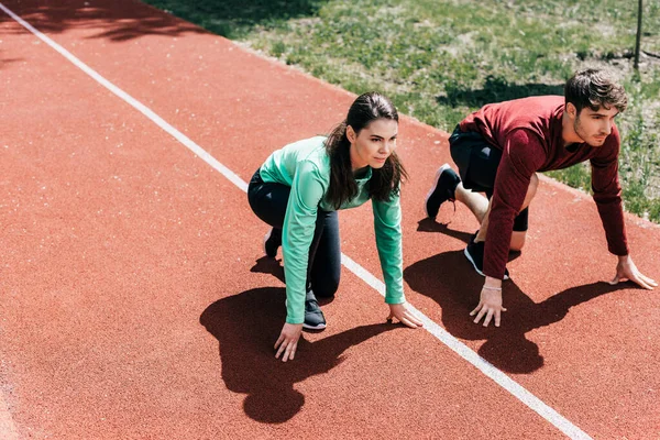 High angle view of couple standing in starting position on track in park — Stock Photo