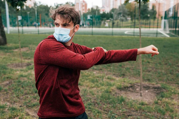 Esportista em treinamento máscara médica no parque — Fotografia de Stock