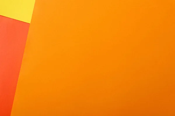 Fond géométrique abstrait avec du papier brillant rouge, jaune et orange — Photo de stock