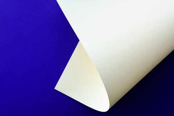 Papier coloré blanc tourbillonnant sur fond bleu — Photo de stock