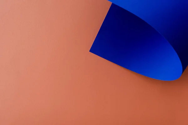 Papel colorido azul sobre fondo naranja - foto de stock