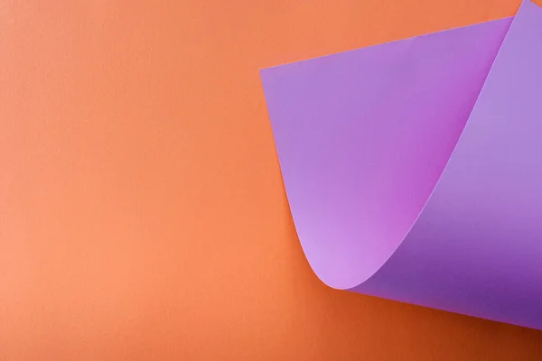 Papel de color violeta sobre fondo naranja - foto de stock
