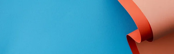 Помаранчевий барвистий паперовий вихор на синьому фоні, панорамний знімок — стокове фото
