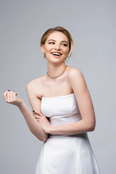 Attraktive Braut im weißen Brautkleid lacht vereinzelt auf grau — Stockfoto