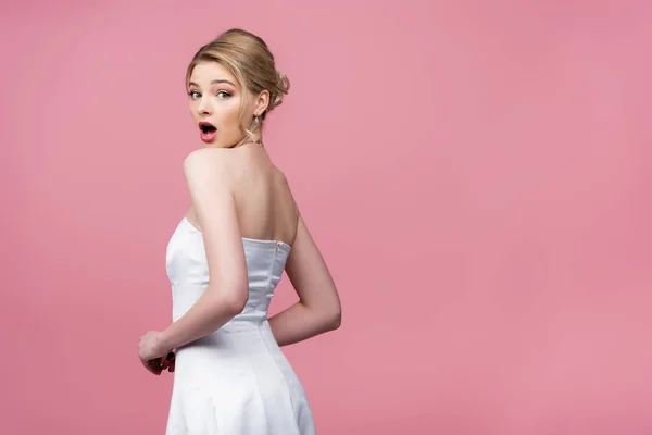 Shocked bride in white wedding dress looking at camera isolated on pink — Stock Photo