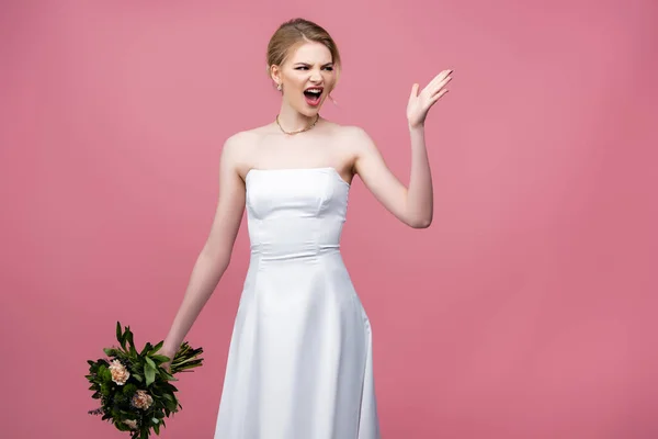 Wütende Braut im weißen Hochzeitskleid mit Blumen und gestikulierend auf rosa — Stockfoto