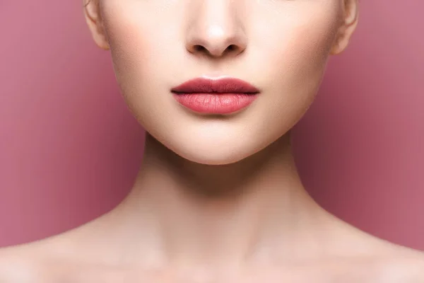 Cropped view of young woman with lipstick on lips on pink — Stock Photo