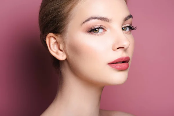 Nude and young woman with makeup looking at camera on pink — Stock Photo