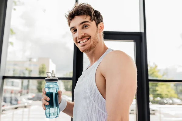 Deportista feliz celebración de la botella de deportes con agua - foto de stock