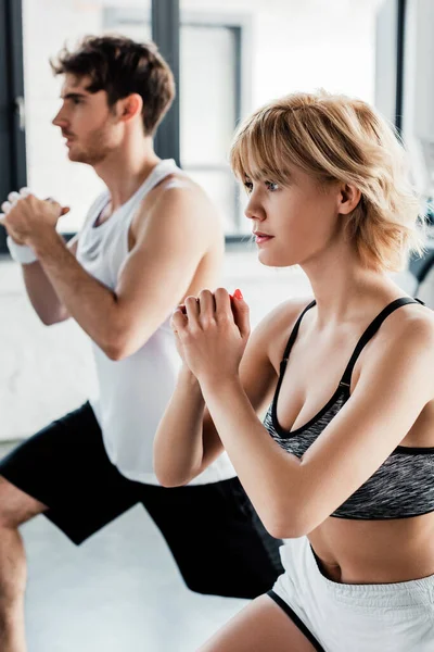 Messa a fuoco selettiva della coppia sportiva con le mani strette che si allenano in palestra — Foto stock