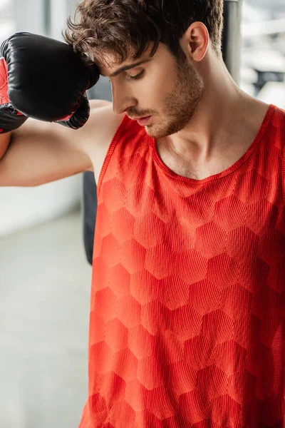 Homme épuisé en vêtements de sport et gant de boxe toucher le visage — Photo de stock