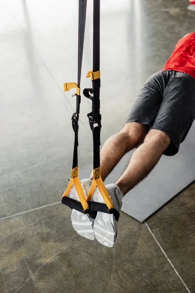 Vista cortada de desportista exercício com elásticos perto de tapete de fitness — Fotografia de Stock