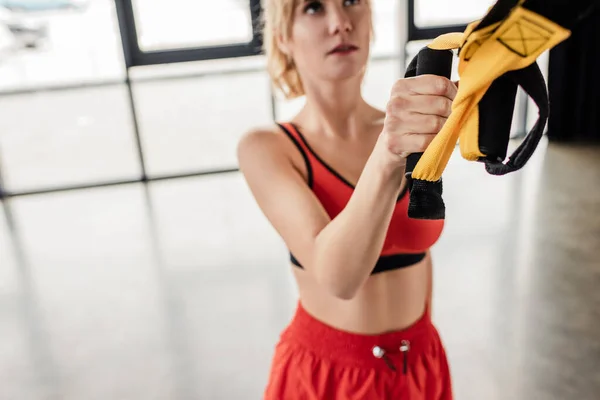 Selektiver Fokus der jungen Frau, die im Fitnessstudio mit Gummibändern trainiert — Stockfoto