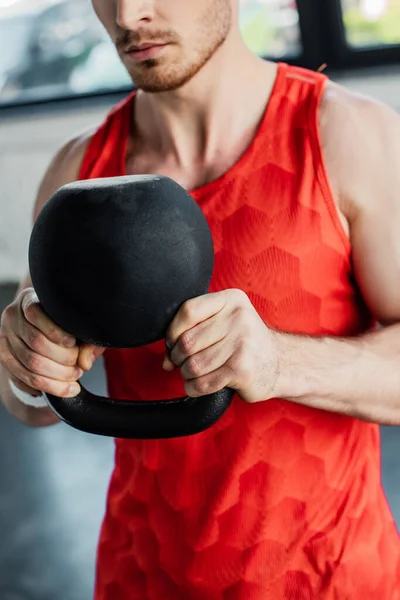 Vue recadrée de l'homme fort exerçant avec haltère lourd dans le centre sportif — Photo de stock