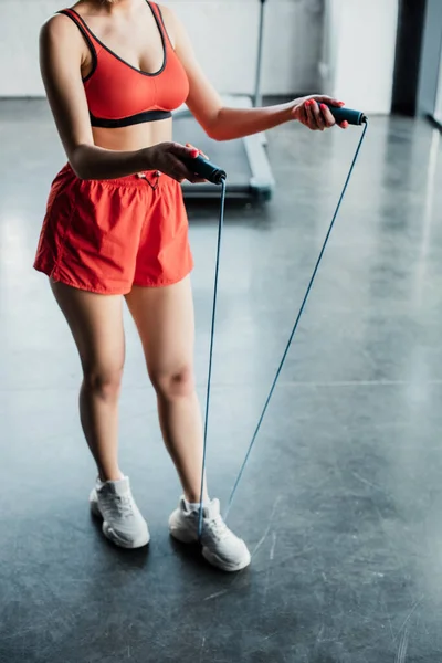 Обрізаний вид спортсменки тримає пропускаючу мотузку в спортзалі — стокове фото
