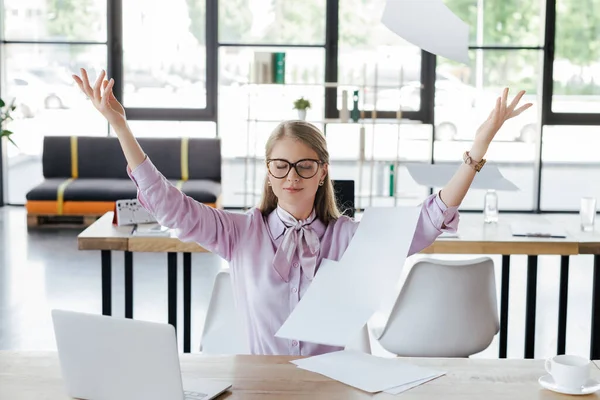 Beautiful businesswoman in glasses throwing in air documents in office — Stock Photo