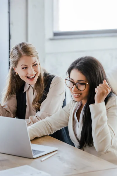 Foyer sélectif des femmes d'affaires excitées célébrant triomphe près d'un ordinateur portable — Photo de stock