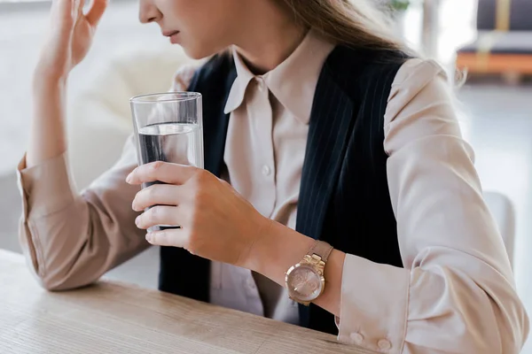 Vue recadrée d'une femme d'affaires tenant un verre d'eau — Photo de stock