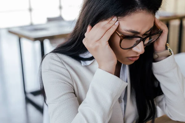 Mujer de negocios cansada en gafas con dolor de cabeza - foto de stock