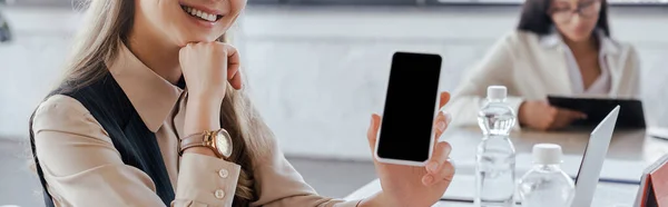 Panoramic crop of businesswoman holding smartphone with blank screen — Stock Photo