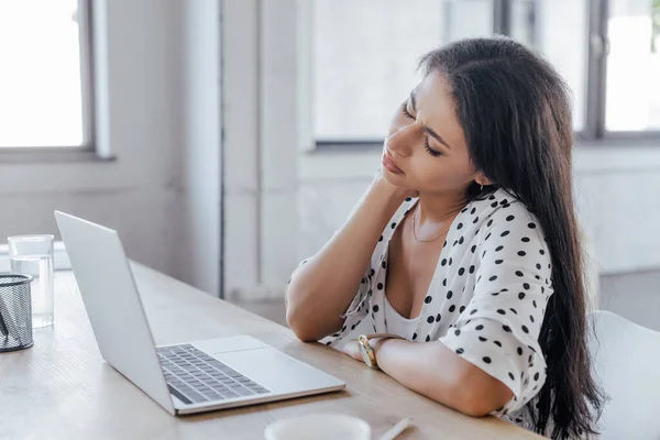 Foyer sélectif de belle femme d'affaires touchant le cou tout en souffrant de douleur au bureau — Photo de stock