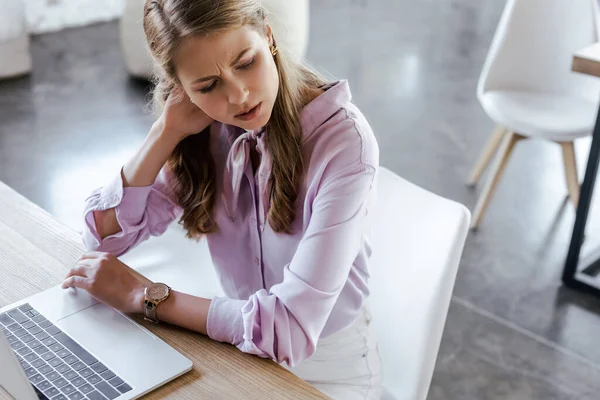 Geschäftsfrau berührt unter Schmerzen Hals in der Nähe von Laptop — Stockfoto