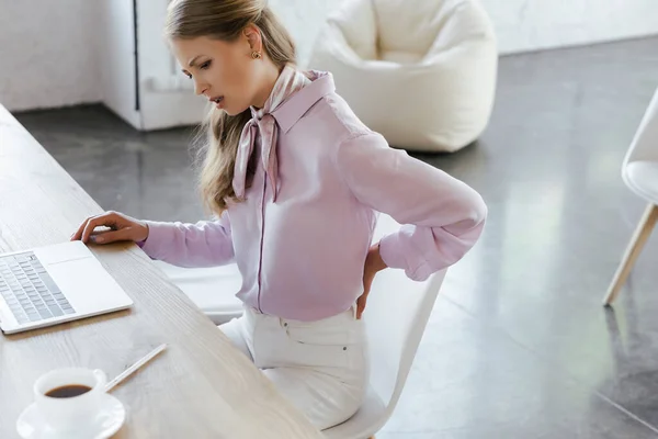 Concentrazione selettiva della donna d'affari che sente dolore mentre si tocca di nuovo in carica — Foto stock