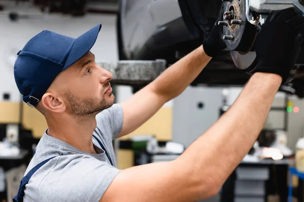 Perfil del mecánico en la reparación de la tapa del coche en la estación de servicio - foto de stock