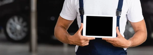 Colheita horizontal de mecânico em macacão segurando tablet digital com tela em branco no serviço de carro — Fotografia de Stock