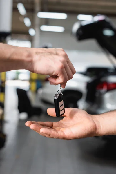 Foco seletivo do homem recebendo a chave do carro na estação de serviço — Fotografia de Stock