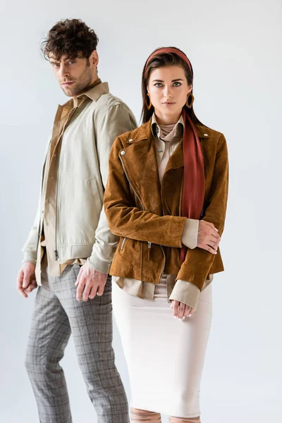 Young, stylish couple looking at camera while posing isolated on white — Stock Photo