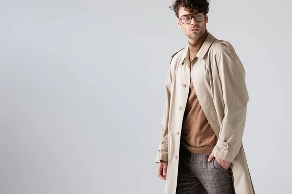 Bell'uomo alla moda che tiene la mano in tasca e distoglie lo sguardo isolato sul grigio — Foto stock