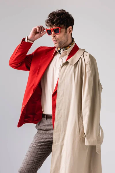 Selbstbewusster, stylischer Mann mit Sonnenbrille, während er isoliert von grau wegschaut — Stockfoto