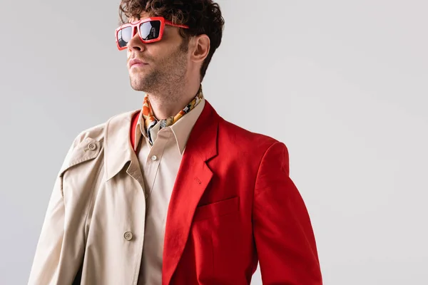 Homme à la mode, confiant dans les lunettes de soleil regardant loin isolé sur gris — Photo de stock