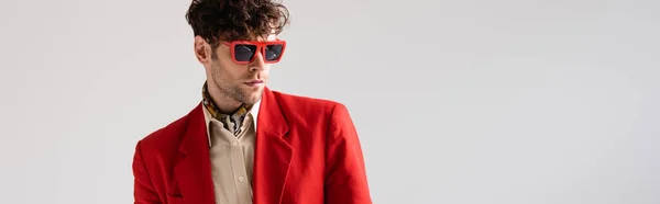 Заголовок веб-сайту модного чоловіка в червоних блейзерах і сонцезахисних окулярах ізольовано на сірому — стокове фото