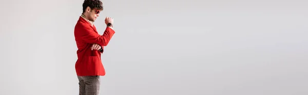 Side view of fashionable man in red blazer posing isolated on grey, website header — Stock Photo