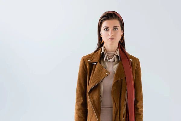 Vue de face de la jolie femme en veste regardant la caméra isolée sur gris — Photo de stock