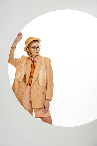 Stylish girl in straw hat and eyeglasses standing near circle on white background — Stock Photo