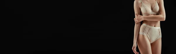 Image horizontale de la femme en sous-vêtements touchant le bras isolé sur noir — Photo de stock