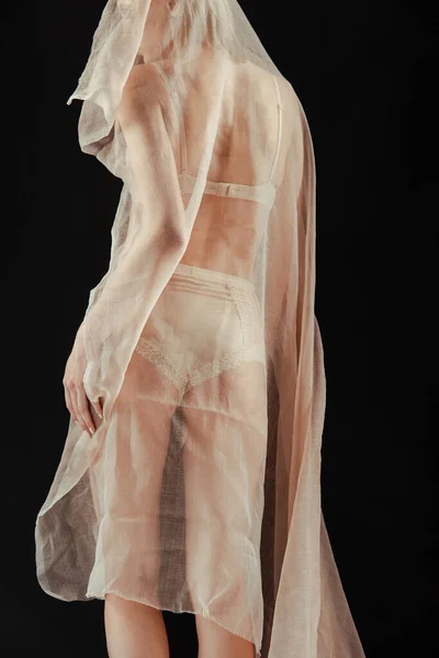 Cropped view of girl in beige underwear and chiffon cloth isolated on black — Stock Photo