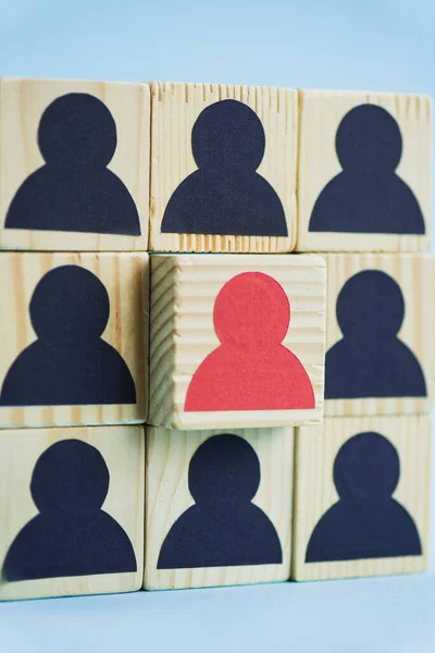 Square of wooden blocks with black and red human icons on blue background, leadership concept — Stock Photo