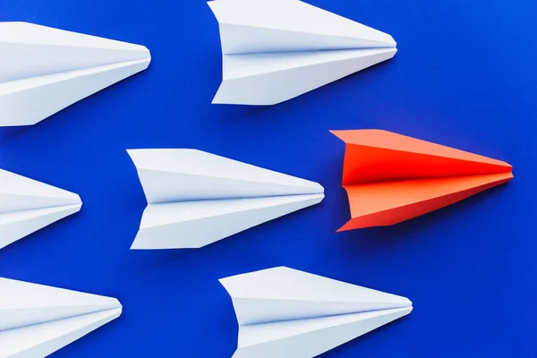 Top view of white and red paper planes on blue background, leadership concept — Stock Photo